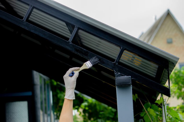 girl paint with a brush black metal. paints the roof